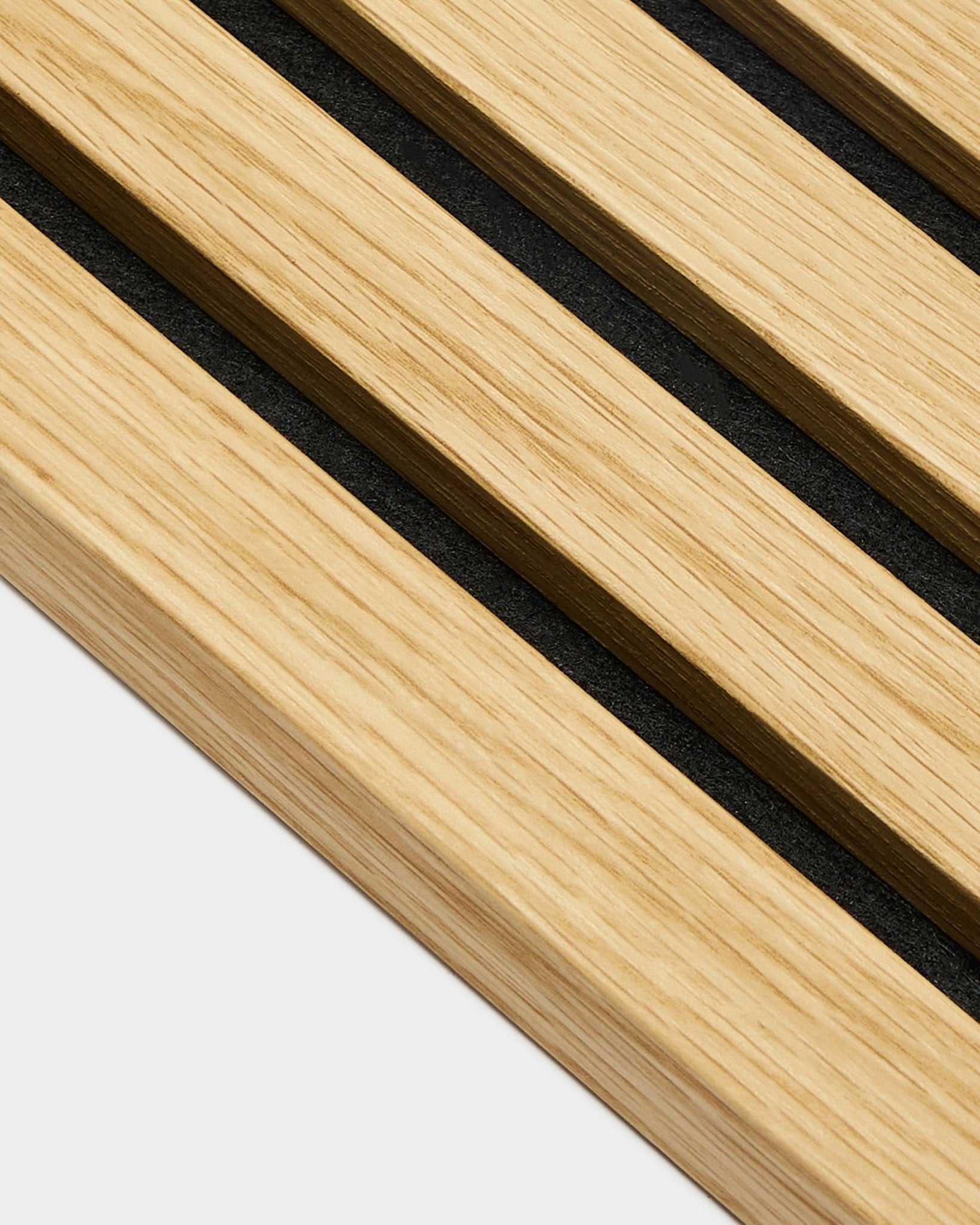 Nærbilde av WoodUpp Akupanel endelamell i Southern Oak, 2,2 cm brede spiler med black mellomrom, arrangert diagonalt på en lys grey bakgrunn.